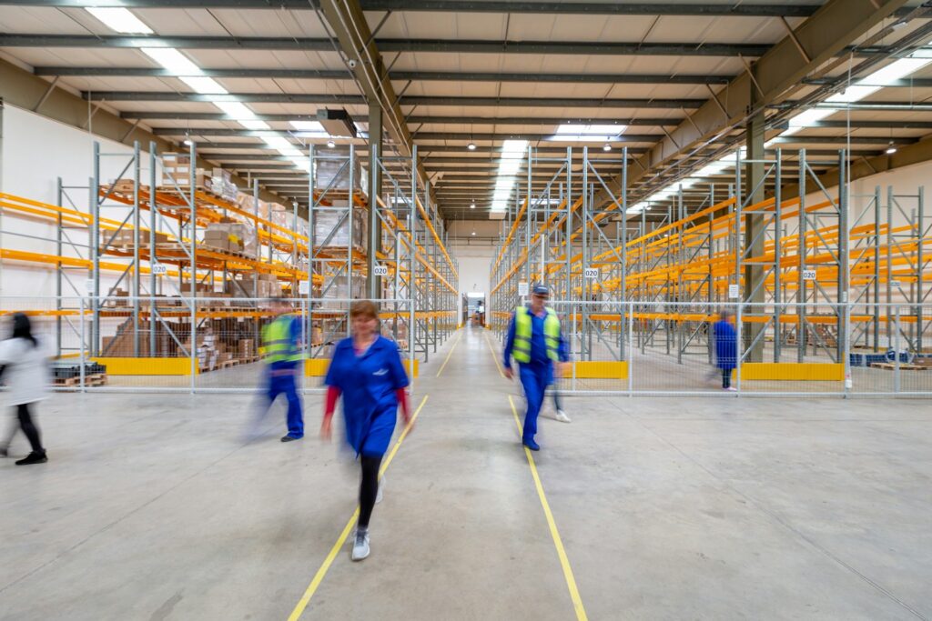 Photo by Adrian Sulyok man in blue jacket and blue pants walking on yellow metal frame
