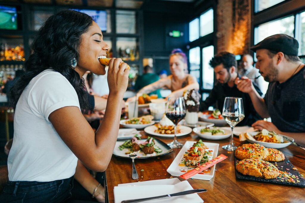 Photo by Alex Haney woman in white shirt eating